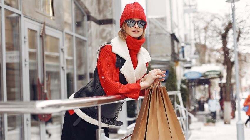 kobieta w czerwonej czapce, kurtce z zakupami