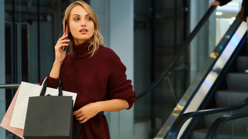 kobieta z zakupami w galerii rozmawia przez telefon